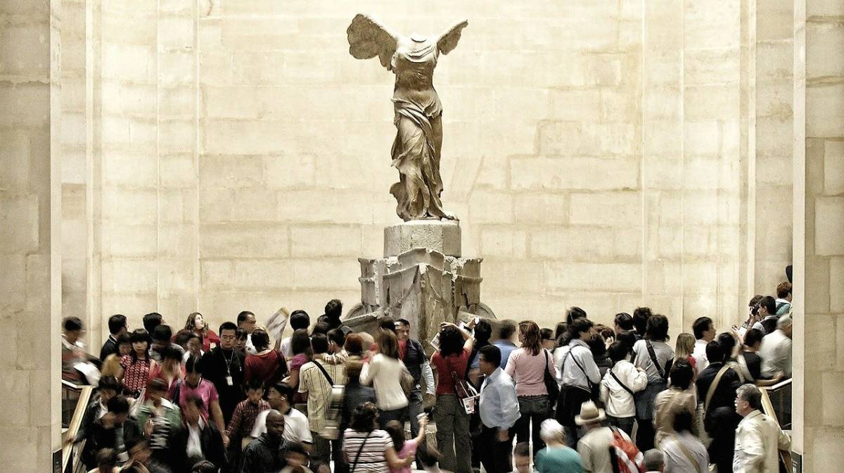 Museu do Louvre: a Vitória de Samotrácia e a multidão.